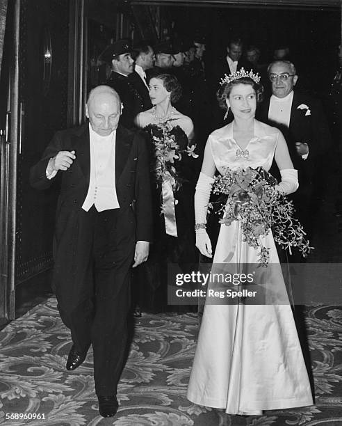 Queen Elizabeth II is escorted by Reginald Bromhead, the Chairman of the Cinematograph and Trade Benevolent Fund, as she and Princess Margaret leave...