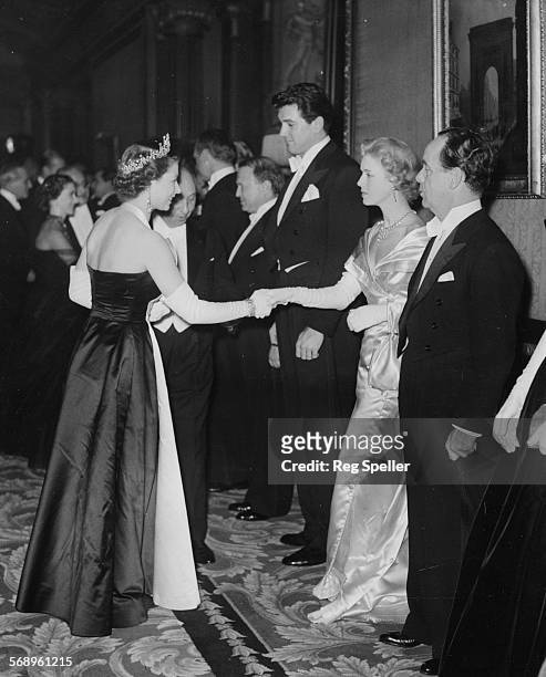 Actress Veronica Hurst, with actor Rock Hudson on her right) being presented to Queen Elizabeth II at the Royal Film Performance in Leicester Square,...