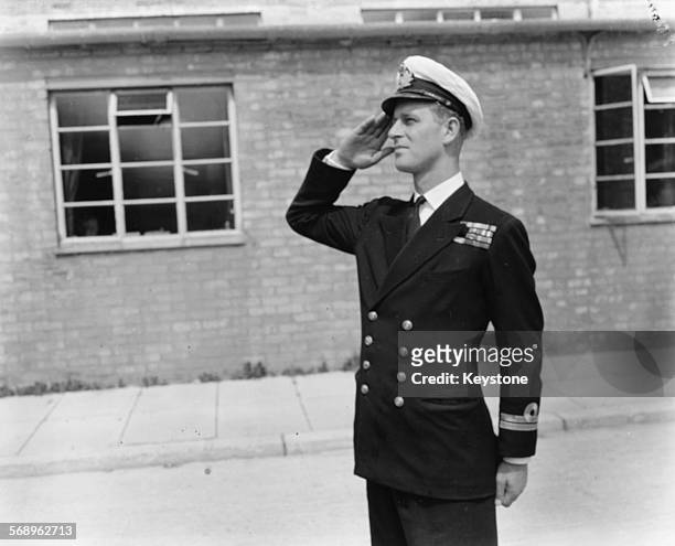 Lieutenant Philip Mountbatten, prior to his marriage to Princess Elizabeth, saluting as he resumes his attendance at the Royal Naval Officers School...