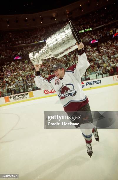 American professional hockey player Chris Drury of the Colorado Avalanche skates around the rink with the Stanley Cup over his head in celebration of...