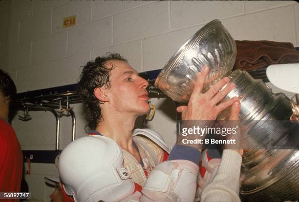 American professional hockey player Joe Mullen of the Calgary Flames drinks from the Stanley Cup as he celebrates their championship victory over the...