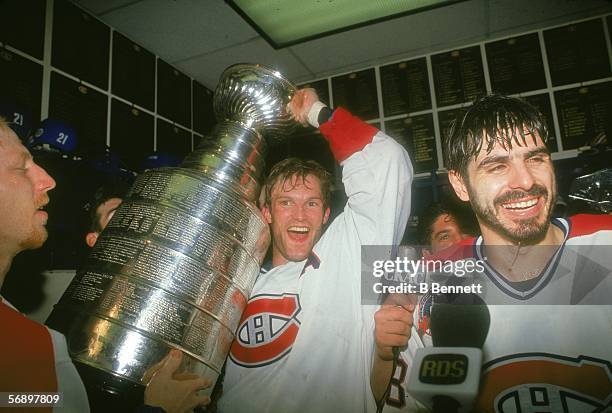 Canadian professional hockey player Kirk Muller of the Montreal Canadiens hoists the Stanley Cup over his head as he celebrates their championship...