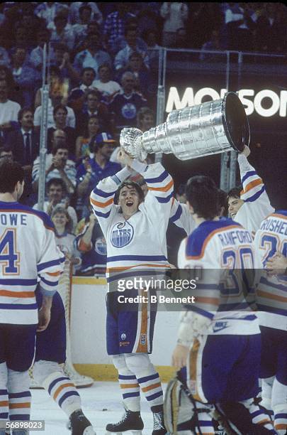 Finnish professional hockey player Jari Kurri of the Edmonton Oilers and Canadian colleague Craig Simpson hoist the Stanley Cup over their heads as...