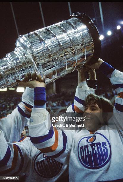 Finnish professional hockey player Jari Kurri of the Edmonton Oilers hoists the Stanley Cup over his head as he celebrates their championship victory...