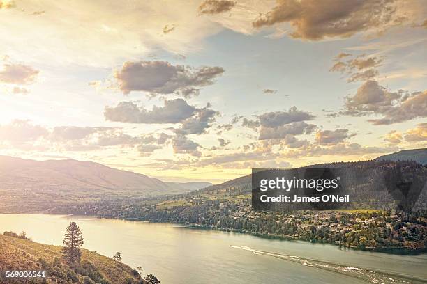 sunset over rolling hills and lake with water ski - kelowna stock pictures, royalty-free photos & images