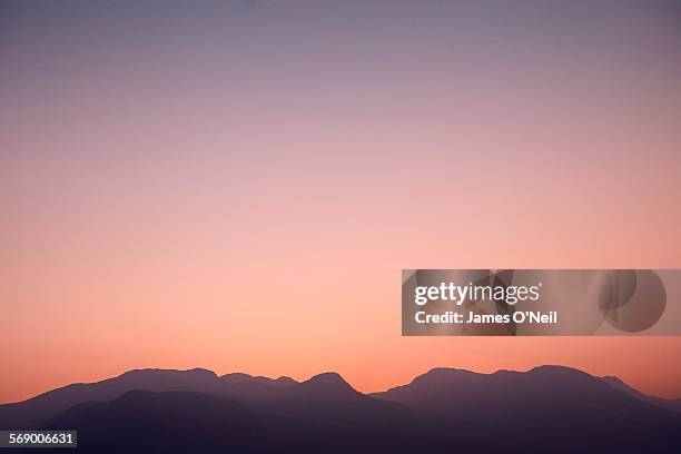 illistrative mountains at sunset - moody sky ストックフォトと画像