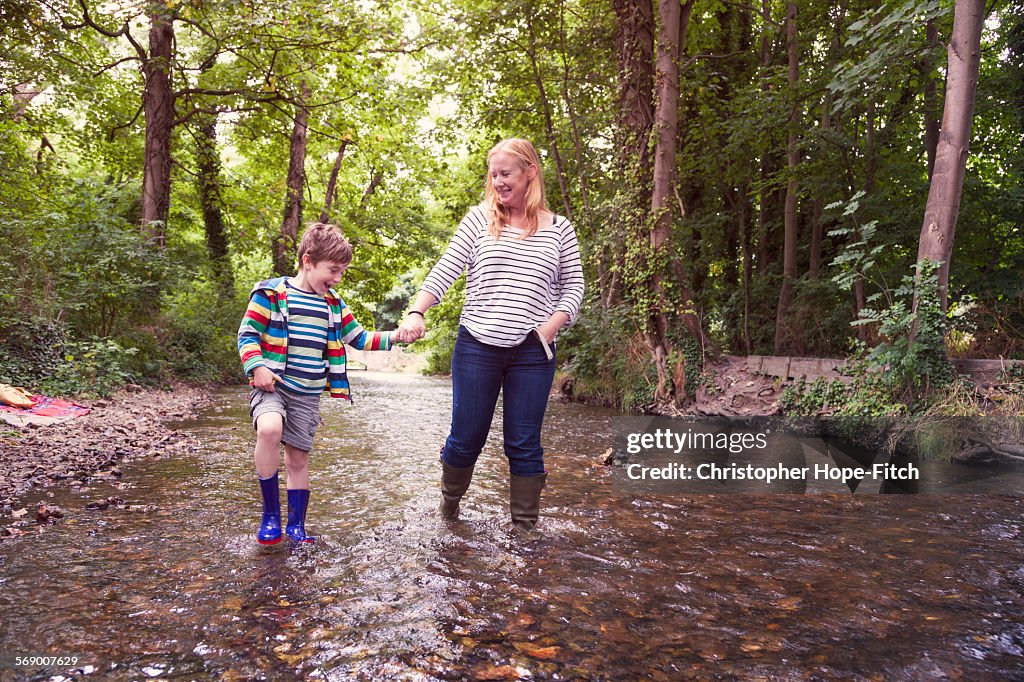 Mother and son walking in a river