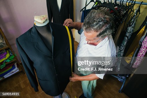 Elderly man while sewing in a tailoring. Elderly man while sewing in a tailoring.