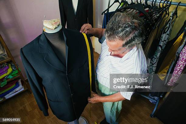 elderly man while sewing in a tailoring. - sewing basket stock pictures, royalty-free photos & images