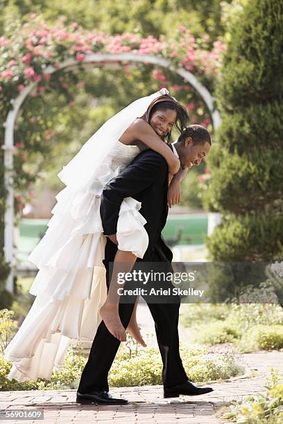 groom carrying bride piggyback - carrying bride stock pictures, royalty-free photos & images