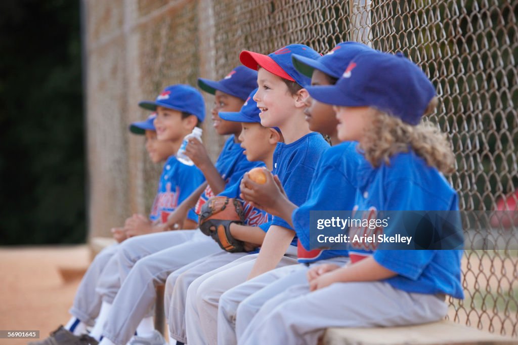 Little League team sitting on bench