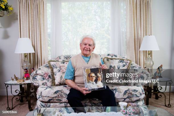 senior man holding photograph - holding photo stock pictures, royalty-free photos & images