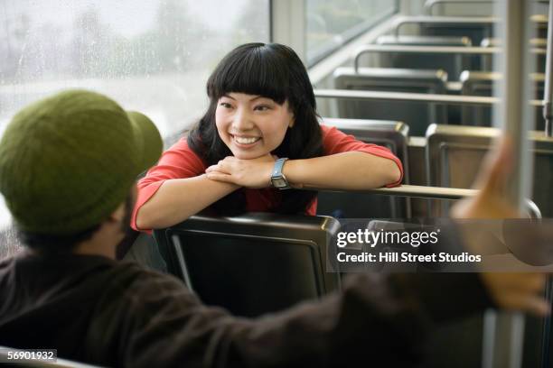 two young adults talking on train - cute asian woman stock pictures, royalty-free photos & images