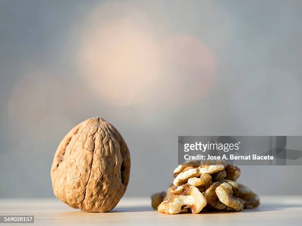 whole peeled walnut and walnut pieces - cáscara de nuez fotografías e imágenes de stock