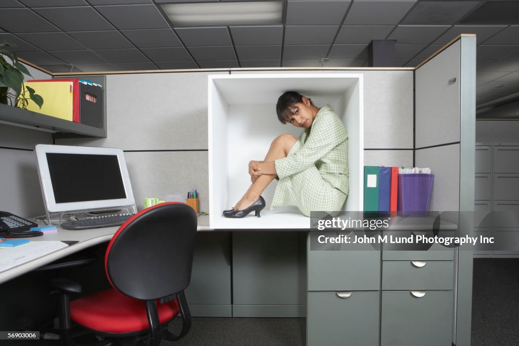 Businesswoman sitting in office cubicle