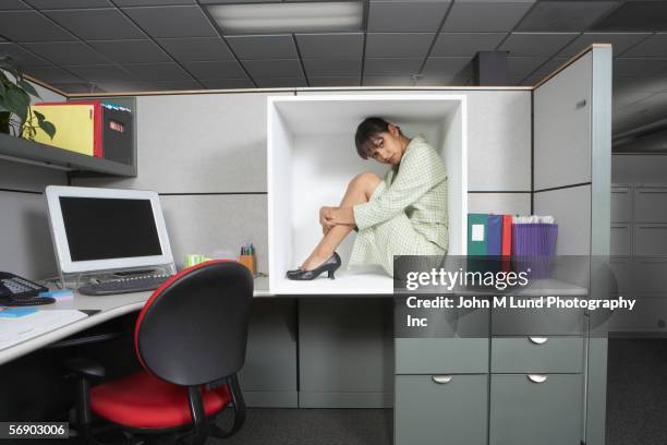 businesswoman sitting in office cubicle - afgesloten ruimte stockfoto's en -beelden