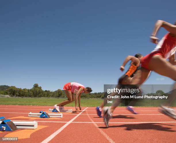 female track runner lagging behind - log stockfoto's en -beelden