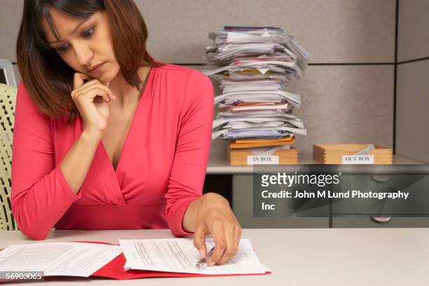 businesswoman reviewing paperwork at desk - service public photos et images de collection