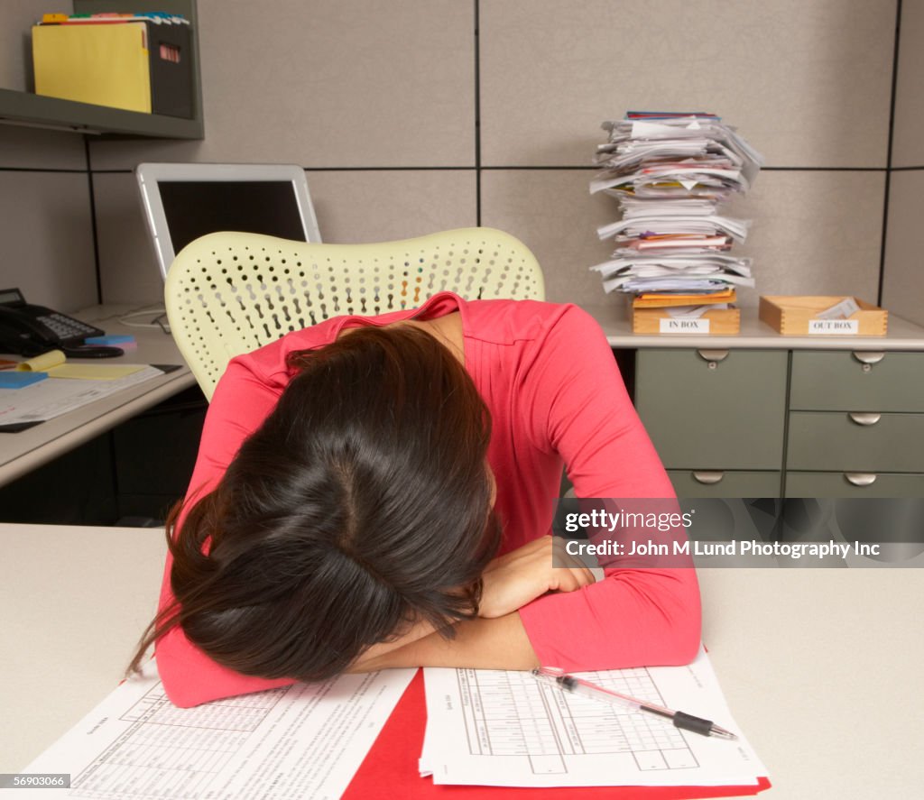 Exhausted businesswoman sleeping at desk