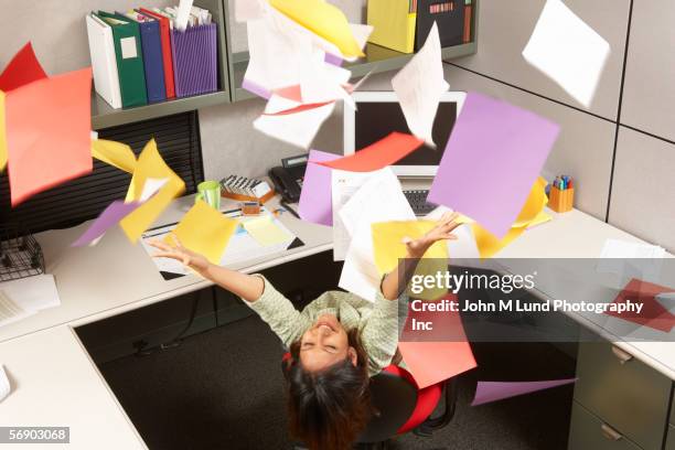 ecstatic businesswoman throwing office papers - quitting a job stockfoto's en -beelden