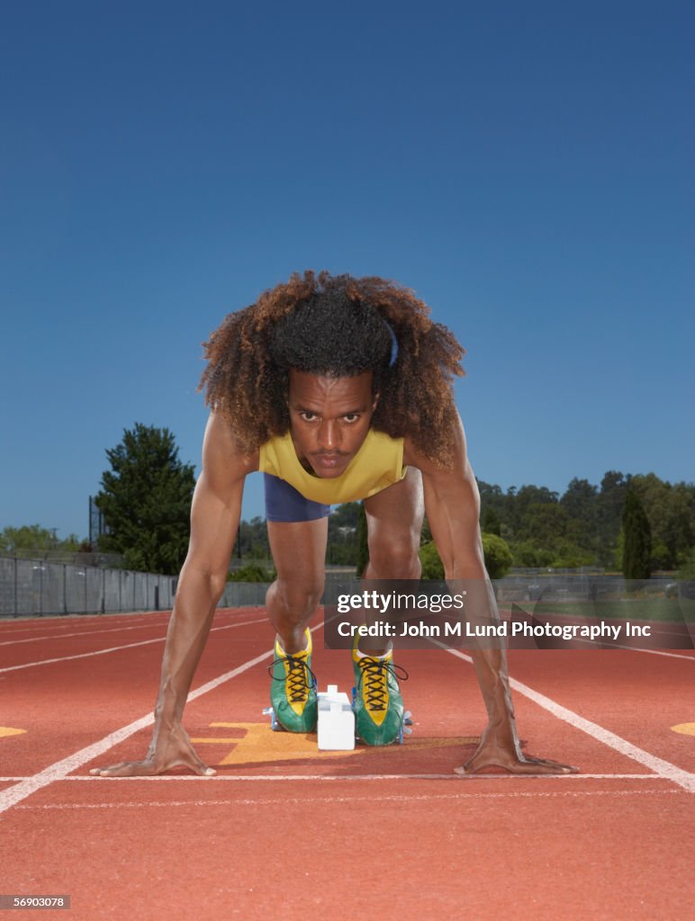 Male track runner preparing to race