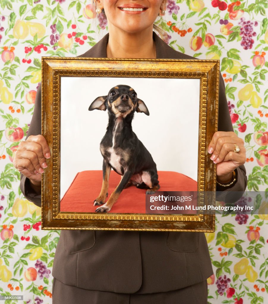 Proud woman holding framed picture of dog