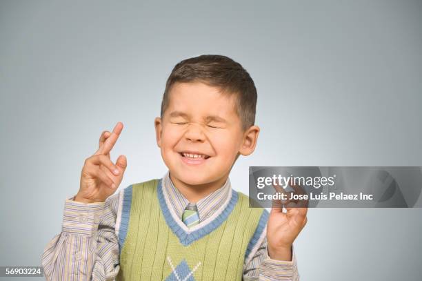 young boy with his fingers crossed - rogar fotografías e imágenes de stock