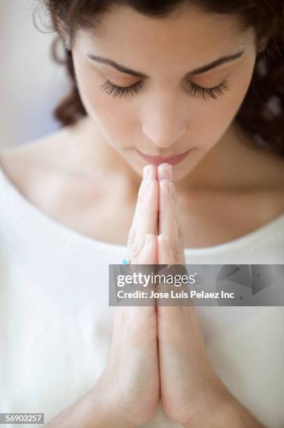 young woman praying - women prayer stock-fotos und bilder