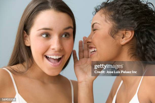 two teenage girls sharing a secret - good news bad news stock pictures, royalty-free photos & images