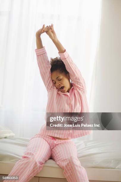 young woman stretching and yawning - pijama fotografías e imágenes de stock