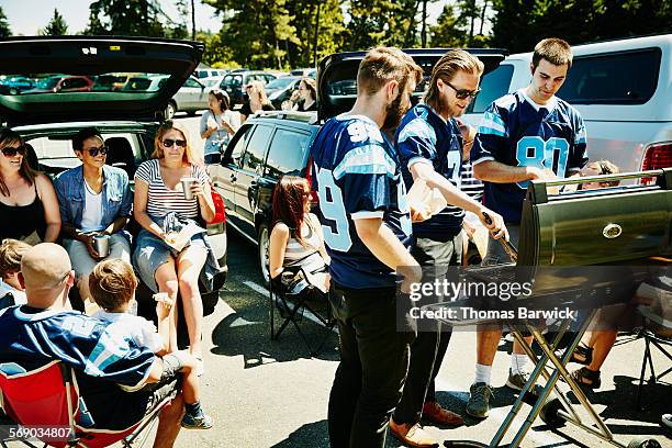 friends barbecuing during tailgating party - game day stock pictures, royalty-free photos & images