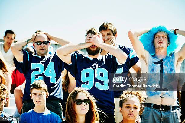 fans in crowd with hands on head after team loss - loss stock pictures, royalty-free photos & images