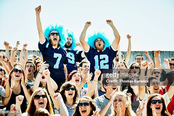 three football fans leading crowd in cheer - fan enthusiast 個照片及圖片檔
