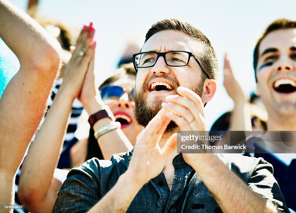 Fan celebrating during football game in stadium