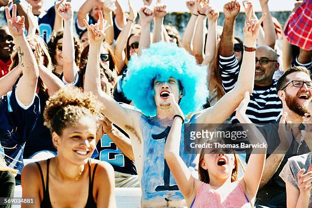 fan leading crowd in cheer during football game - sporting term stock pictures, royalty-free photos & images
