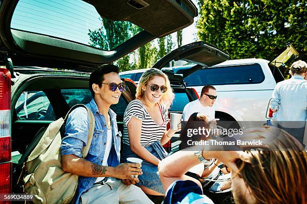 smiling friends tailgating in stadium parking lot - football tailgate stock pictures, royalty-free photos & images