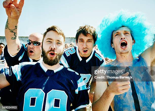 group of football fans yelling in stadium - man wearing sports jersey stock pictures, royalty-free photos & images