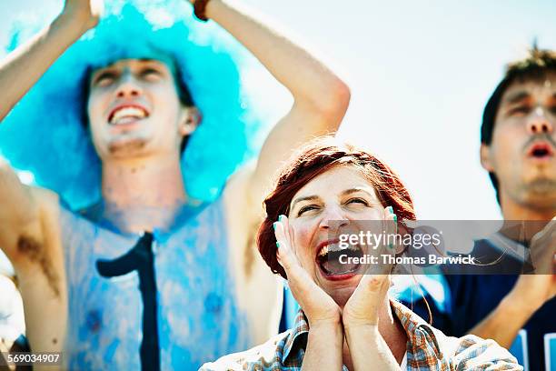 woman yelling with fans during football game - boomwa stock pictures, royalty-free photos & images