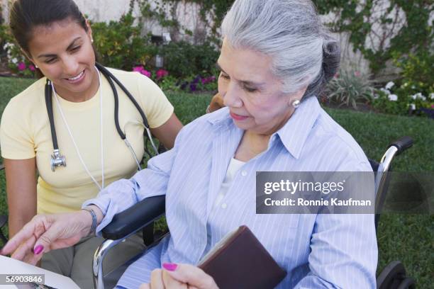 female physician attending senior woman - examining lawn stock pictures, royalty-free photos & images