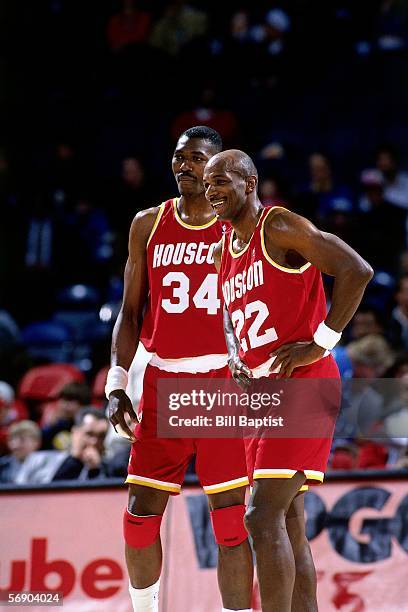 Clyde Drexler and Hakeem Olajuwon of the Houston Rockets enjoy a light moment against the Washington Bullets during an NBA game at the Capital Centre...