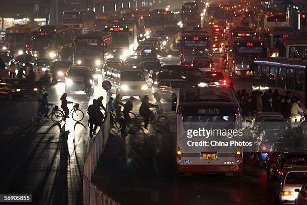 Pedestrians cause a traffic jam as they pass a crossing in the evening at Beijing's main computer district in Zhongguancun, northeast of the capital...