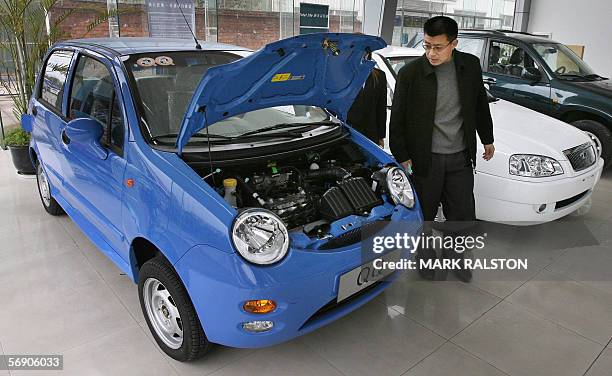 Customer looks at the engine of a Chery QQ car at a dealership of China's largest car exporter, Chery Automobile in Shanghai 22 February 2006. The...