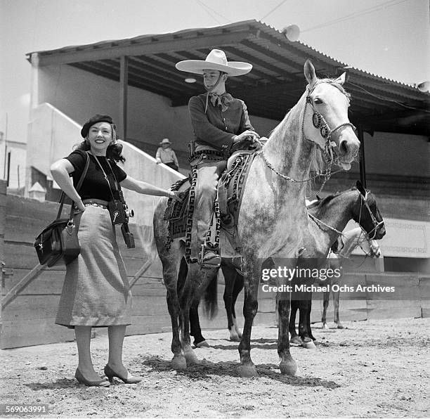 Woman poses next to a vaquero on his horse in Mexico City, Mexico.