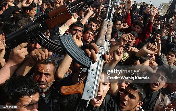 Iraqi Shiite men brandish their weapons as they protest the bombing of a Shiite holy shrine on February 22, 2006 in the Sadr city neighborhood of...