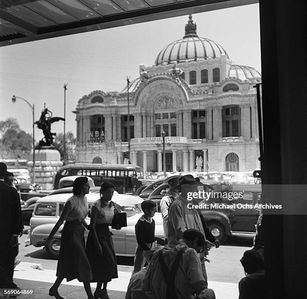 Pedestrians walk across the street of The Palacio de Bellas Artes in Mexico City, Mexico.