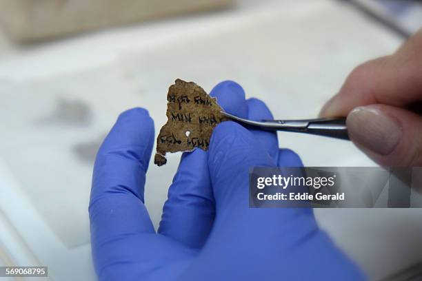 Worker of the Israeli Antiquity Authority sews fragments of the Dead Sea scrolls which includes biblical verses in a preservation laboratory of the...