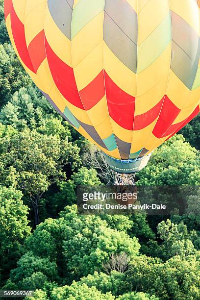 View of hot air balloon with basket of people from above.