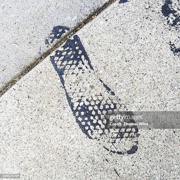 Shoe print on a sidewalk , tar from paved road. Oakland , July 2015