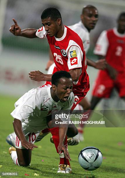 Dubai, UNITED ARAB EMIRATES: Emirati player Ismail Matar fights for the ball with Omani player Khalifa Al-Naufali during their national teams' Asian...