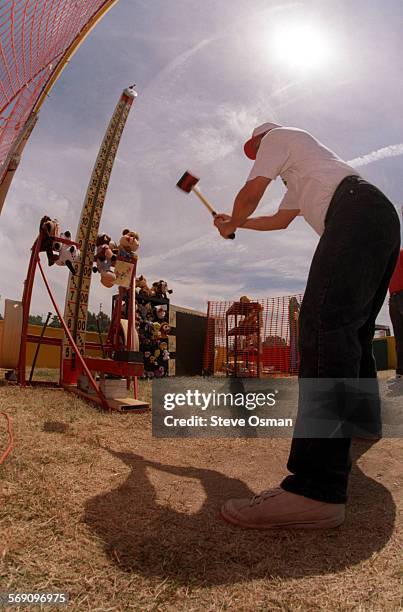 Paul Regina swings a sledge hammer at the Conejo Valley Rotary's "High Striker" booth. Regina, the Public Relations Director with the Suns minor...